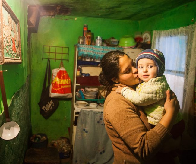 Woman kissing her child in home in Romania