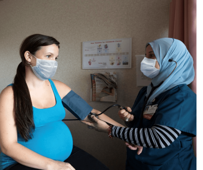 Woman nurse taking a pregnant woman's blood pressure