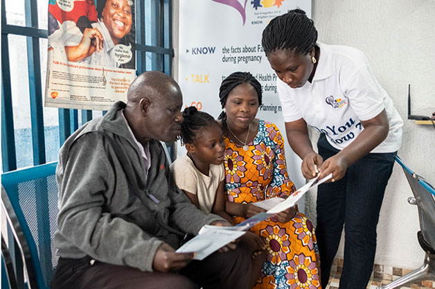 a nurse helping patients fill out paper work