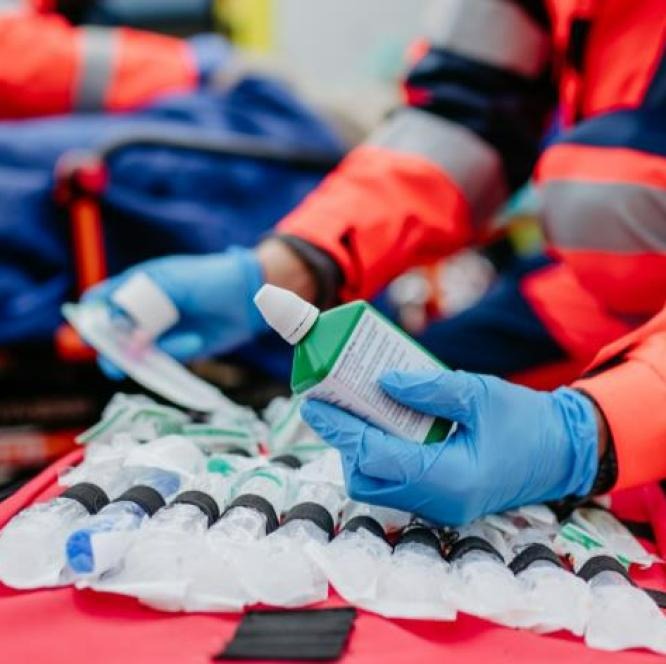 Someone holds medicine wearing latex gloves