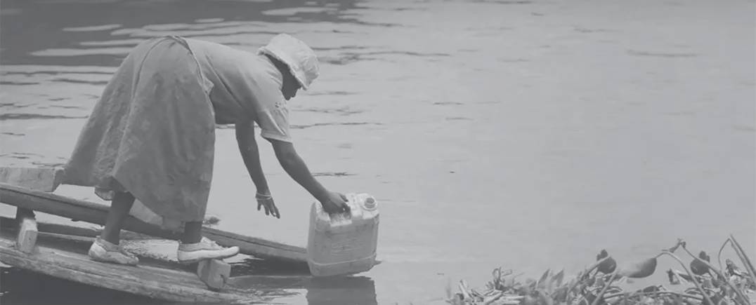 Woman collects water from fresh stream