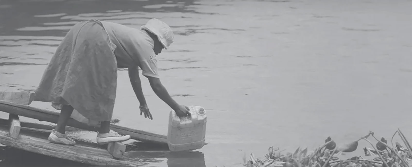 Woman collects water from fresh stream