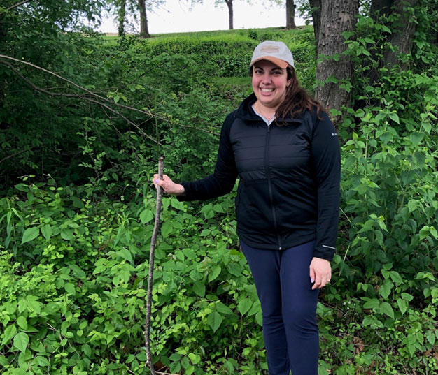 Woman posing with walking stick on hiking trail