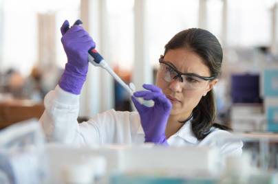 Woman scientist injecting solution into test tube