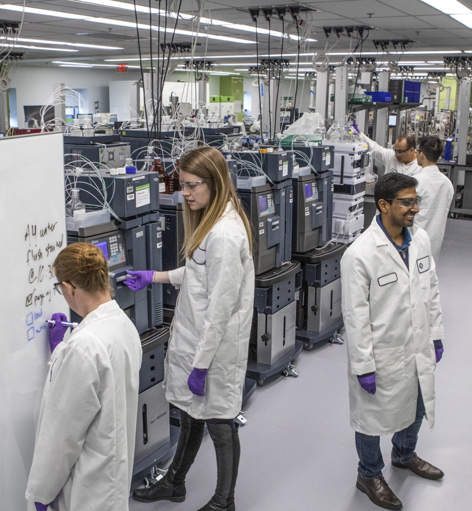 Three lab technicians reviewing findings