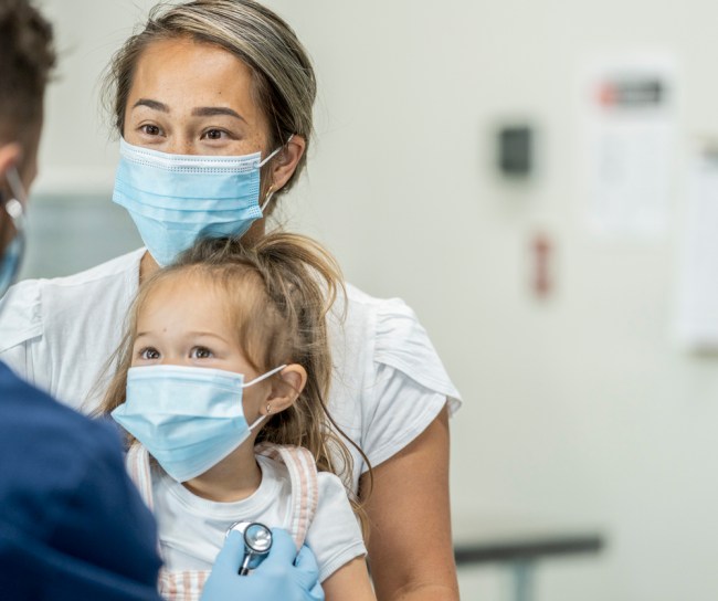 Mom and daughter in masks at the doctors