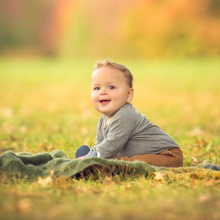 Elise's baby smiling in a field