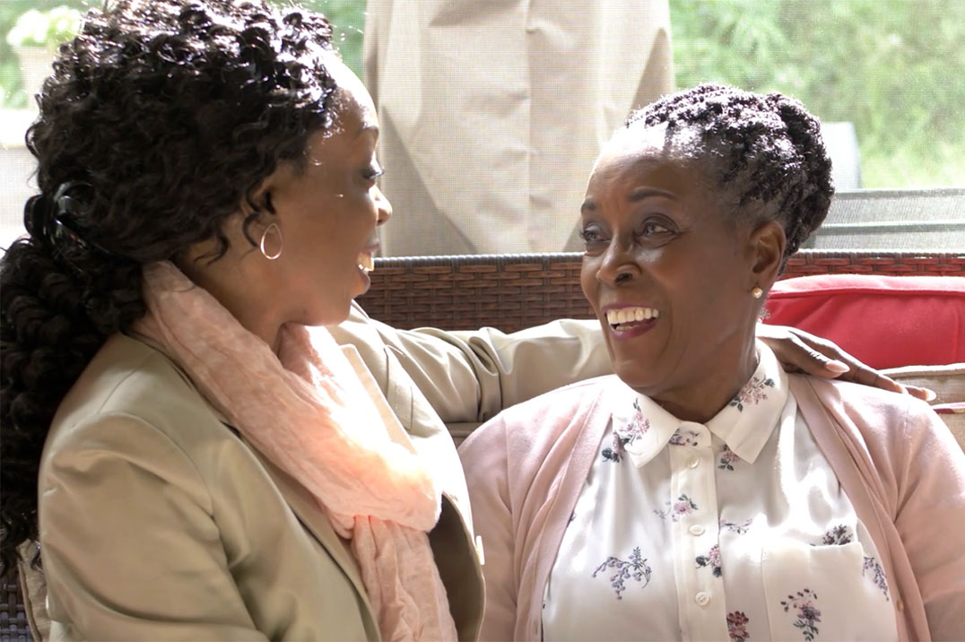 two women sitting and smiling