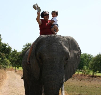 Villar and her son riding an elephant outside of Lusaka, Zambia