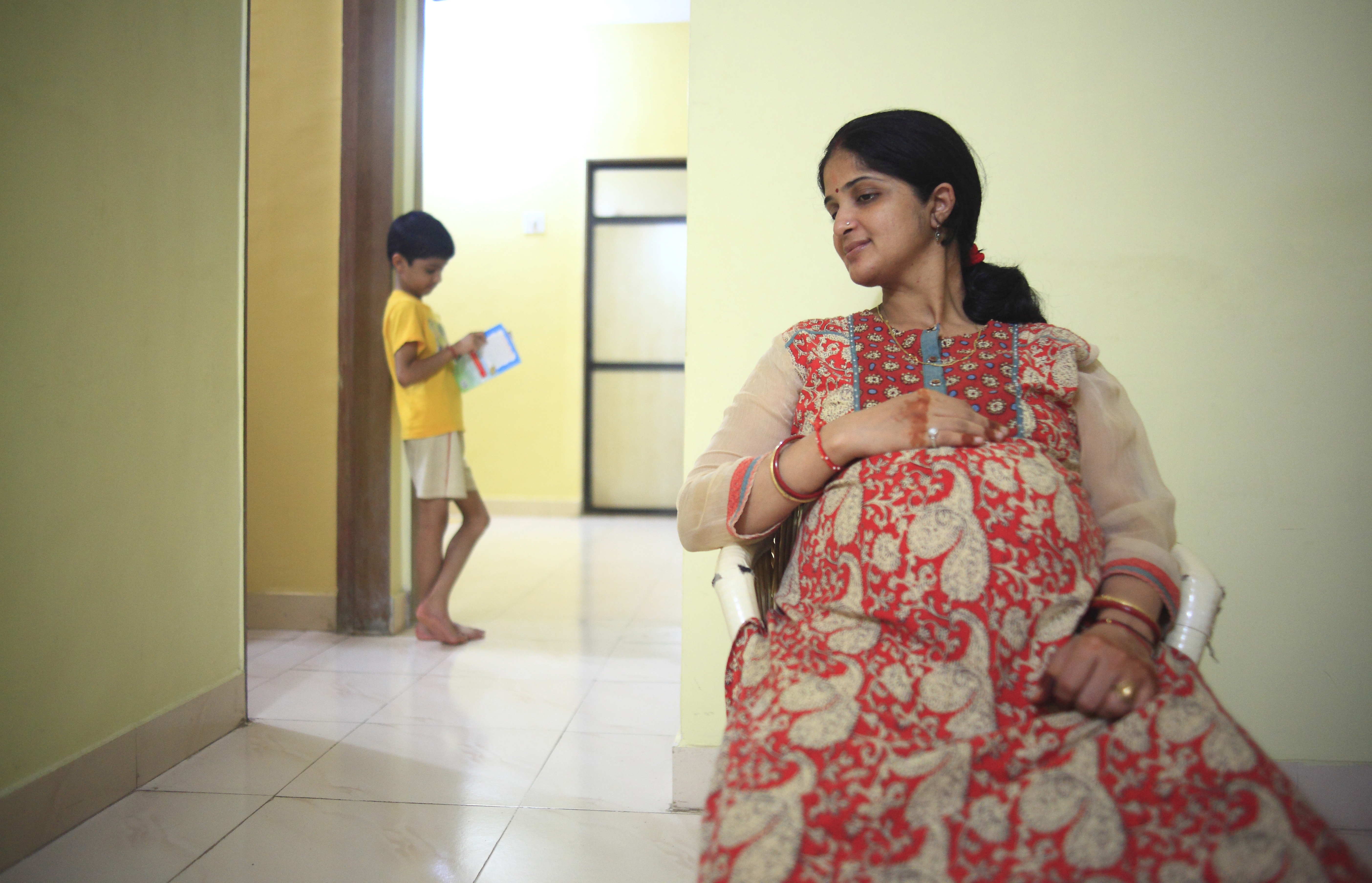 Pregnant woman in India and a child in the background