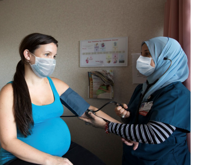 Woman nurse taking a pregnant woman's blood pressure