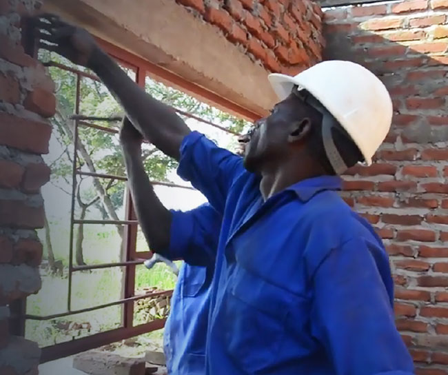 two men working on a brick house