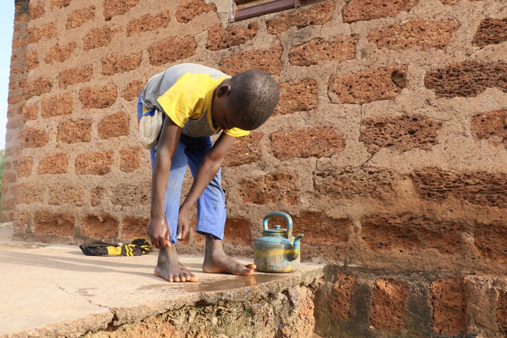 Little boy in Konkourona with water pot
