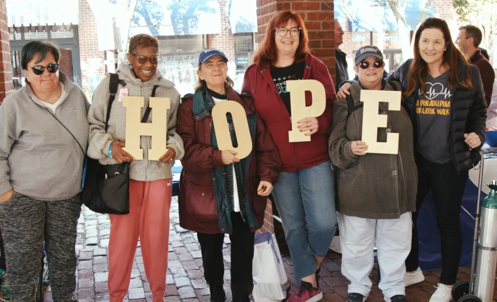 Colleen and friends holding sign that says "HOPE"