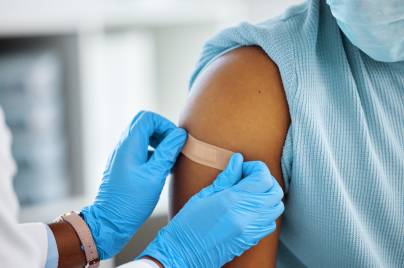 close up of band aid being applied to arm