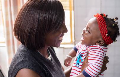 woman smiling and holding a smiling infant