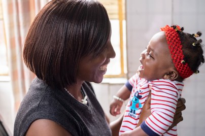 woman smiling and holding a smiling infant