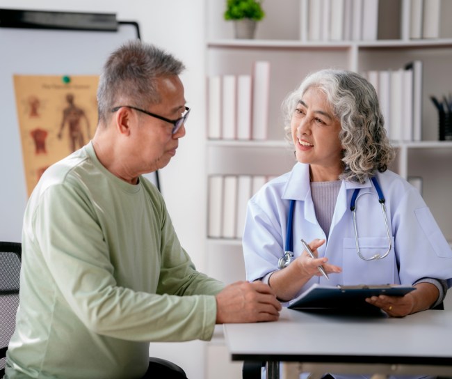Female doctor listening to symptoms of senior patient