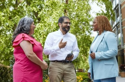 Three employees talking outside the building