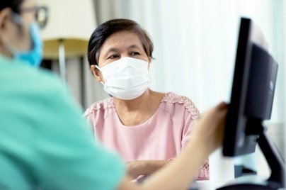Patients wearing a mask talking to doctor