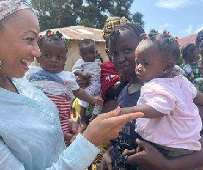 People gathered outdoors holding their child.