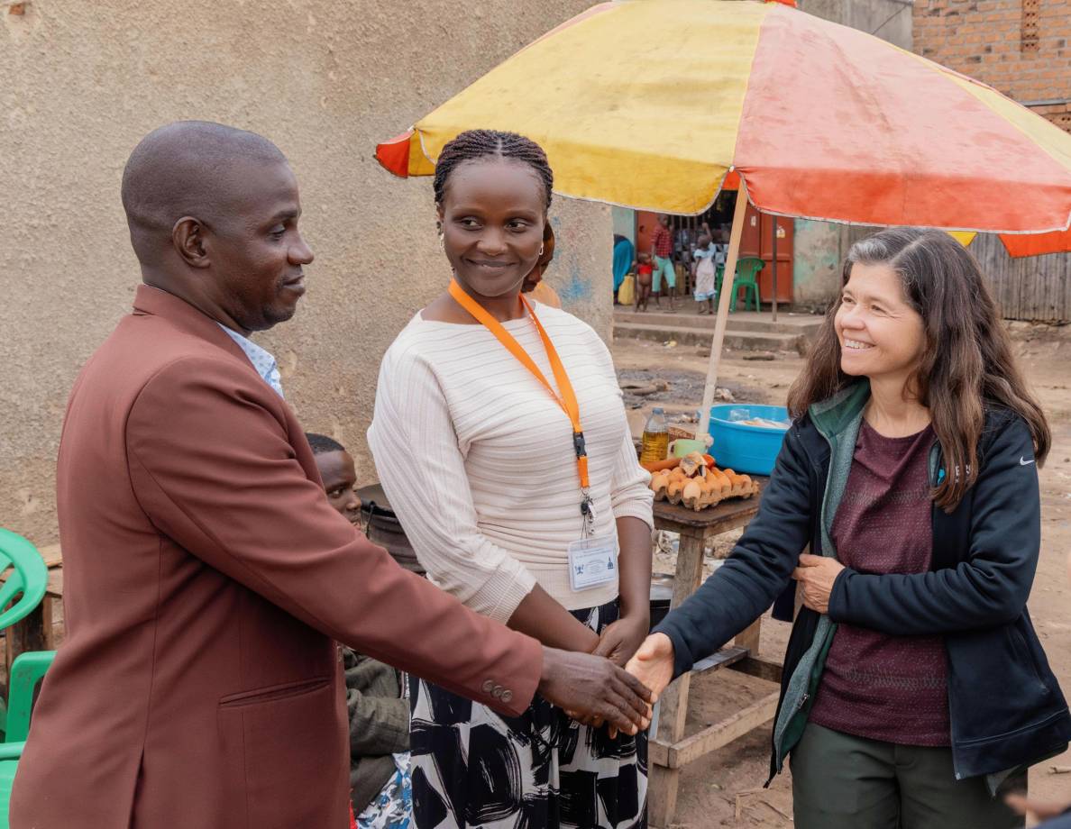 Rebeca Plank, M.D., Ph.D. (right) and Joan Nabawanuka, community liaison officer at MU-JHU Care Ltd., meet with Kibuuka Yahaya Galabuzi, local leader of Katiko Fishing Village in the Mityana district