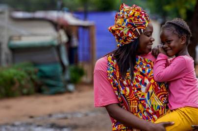 Mother smiling and carrying little girl