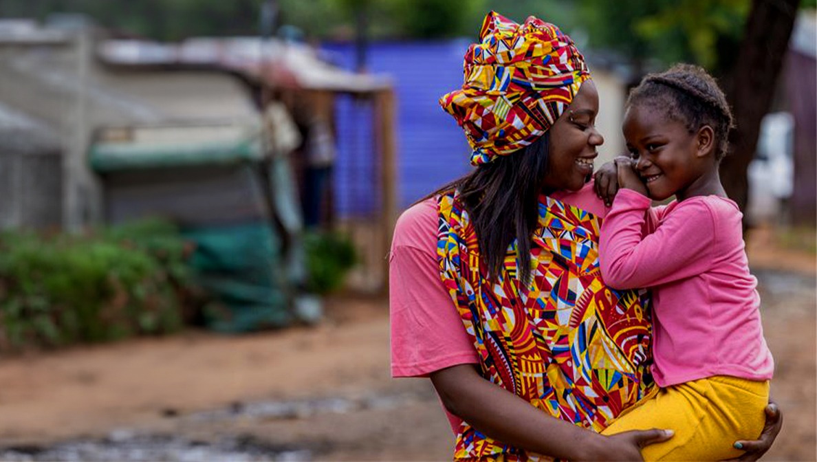 Mother smiling and carrying little girl