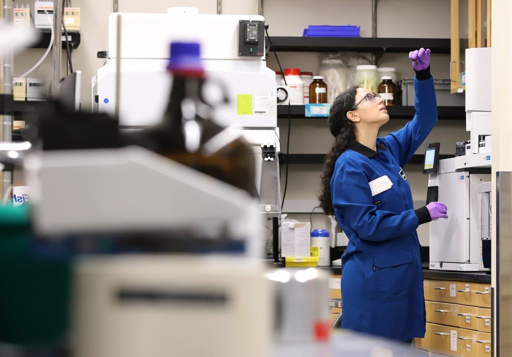 employee examining vial